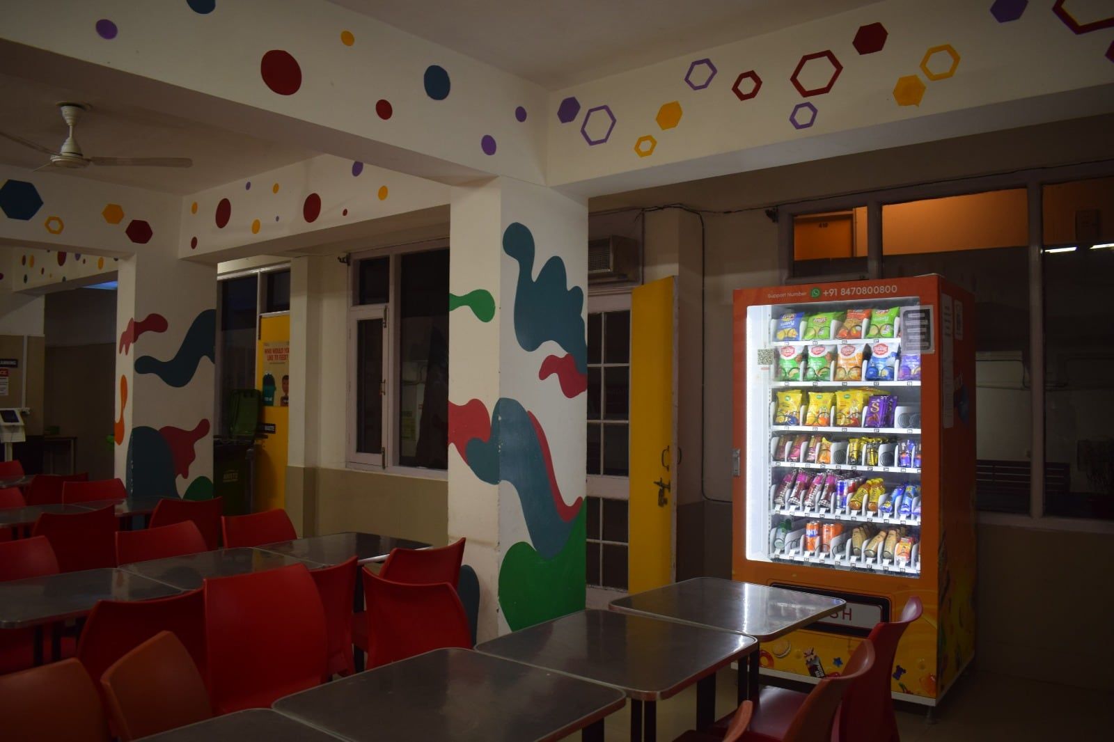 A Wendor machine in a colourful student canteen