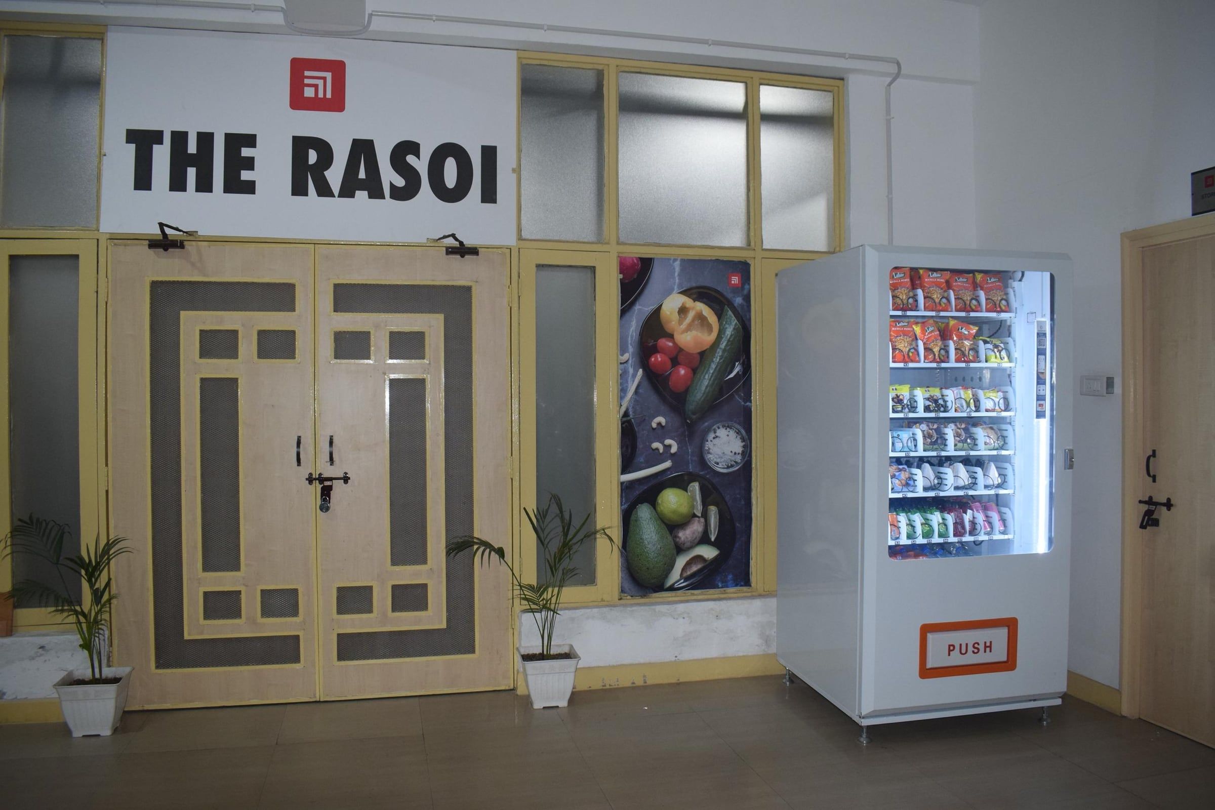 A white Wendor machine beside a campus canteen entrance
