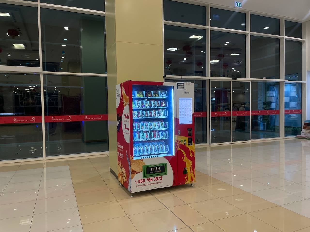 A red Wendor machine in a Dubai mall concourse
