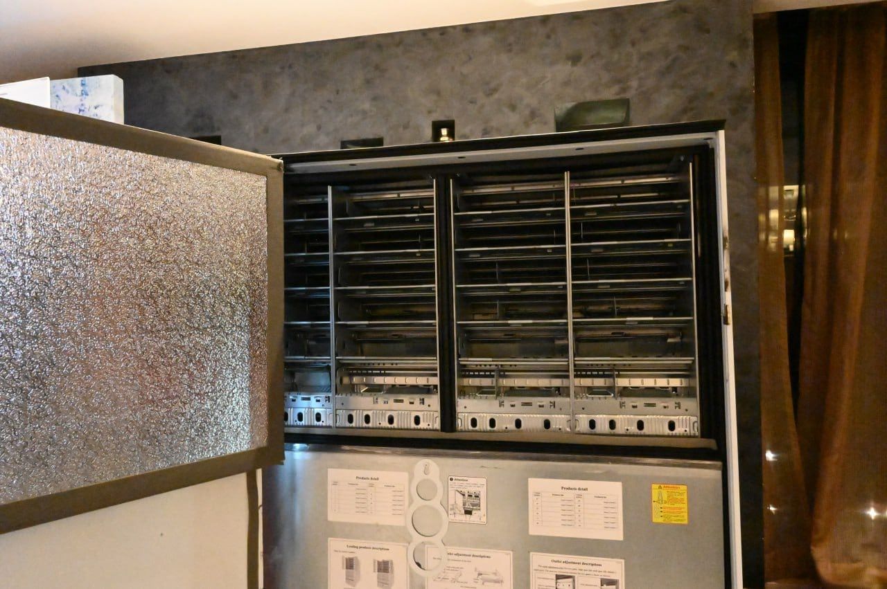 An open Wendor vending machine showing its product lanes and controller