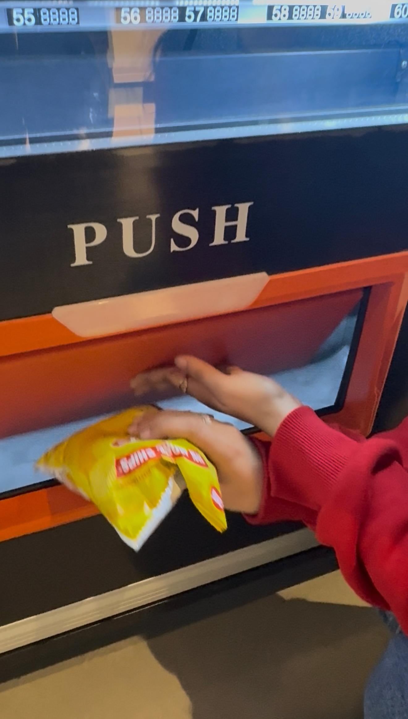 A hand collecting a snack from the pickup flap