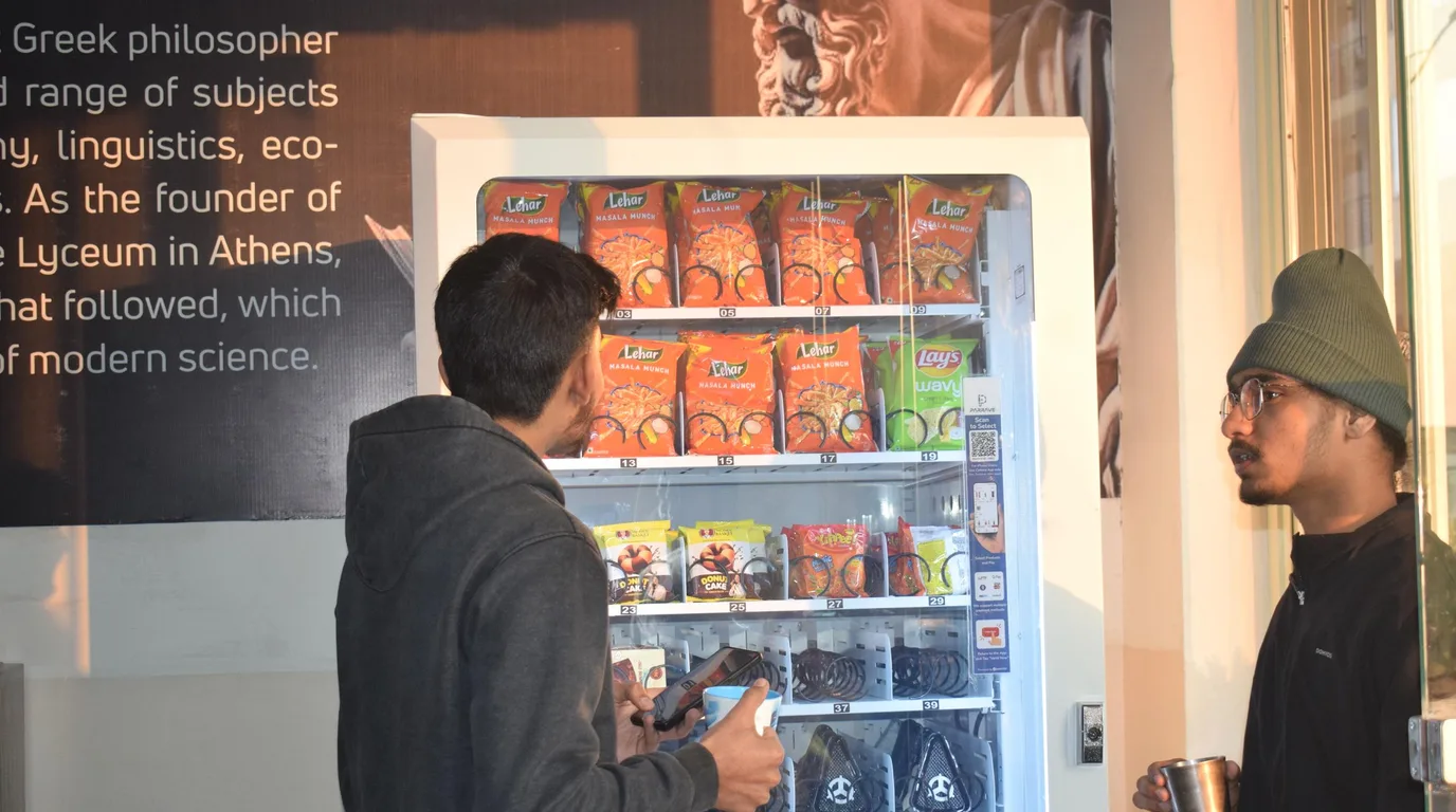 Well-placed vending machine surrounded by tech professionals in a busy IT park lobby