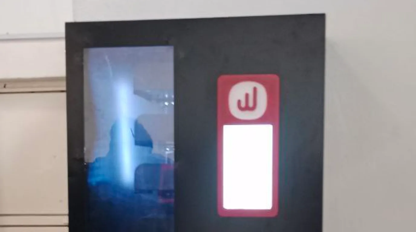 Operator and manager discussing power supply beside a vending machine and wall outlet