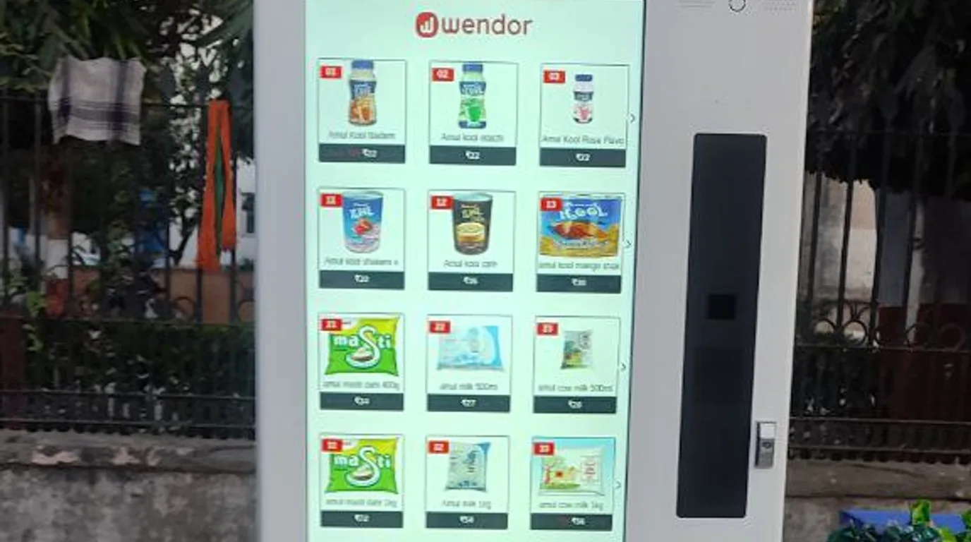 Sales associate showing modern vending machines to a customer in a manufacturer showroom.