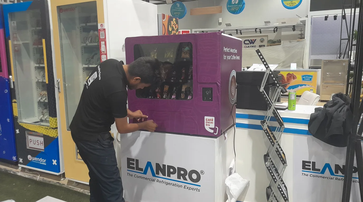 Buyer and technician examining the control board of a used vending machine for issues